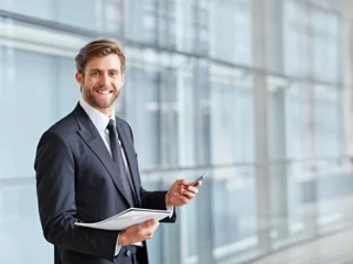 depositphotos_97432250-stock-photo-businessman-smiling-and-holding-phone