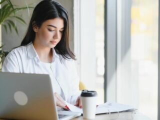 smiling-girl-student-study-online-with-skype-teacher-happy-young-woman-learn-language-listen-lecture-watch-webinar-write-notes-look-at-laptop-sit-in-cafe-distant-education-photo