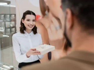 stock-photo-smiling-seller-holding-jewelry-box-blurred-customer-shop-1